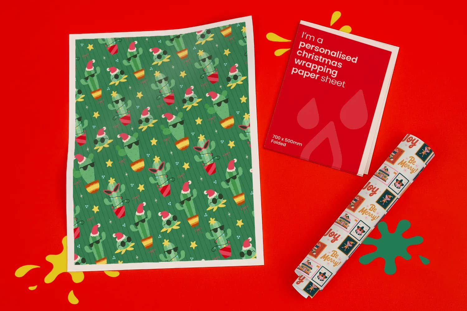 A sheet of cactus-themed Christmas wrapping paper next to a folded sheet and a rolled sheet.