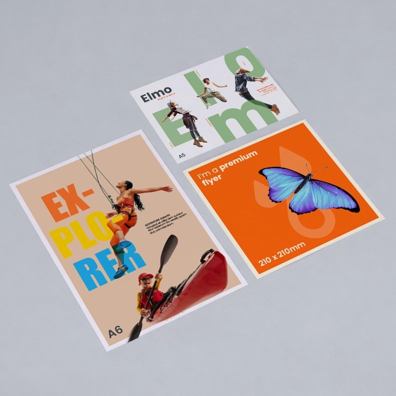 Three colourful A6 flyers on a gray surface, featuring bold text and graphic images.
