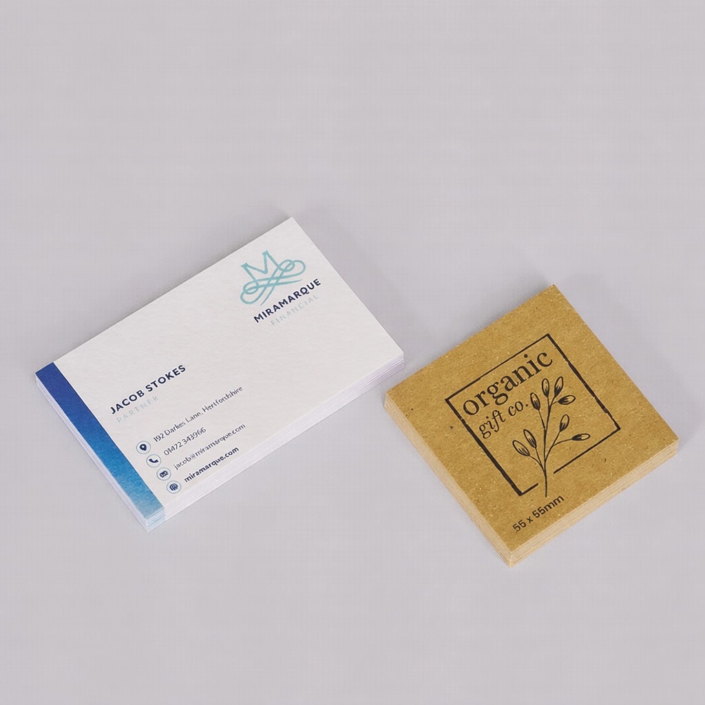 Stack of business cards next to a brown stack of square business cards labeled "organic gift co.
