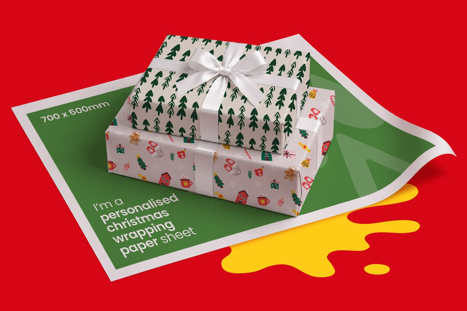 Two gift boxes wrapped in patterned paper sitting on a sheet of personalized Christmas paper.