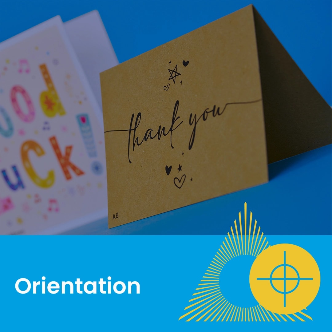 A folded thank you card and a good luck card displayed against a blue background.