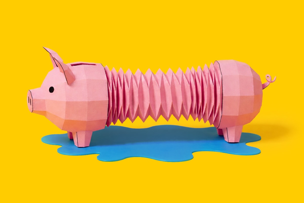 A paper piggy bank with an accordion-like body stands on a blue puddle against a yellow background.